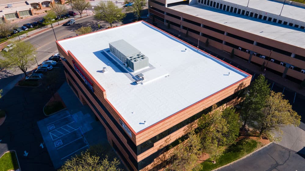 Aerial view of a commercial building with a flat roof and rooftop HVAC unit.